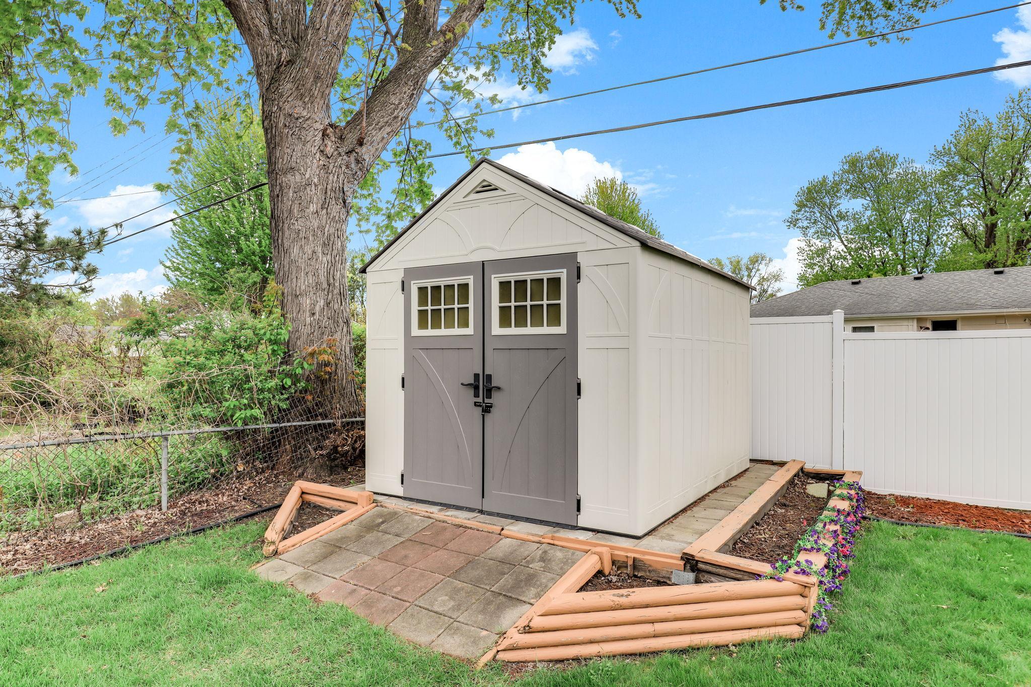 New resin storage shed (2023) featuring durable, weather-resistant construction and ample space for tools and equipment.