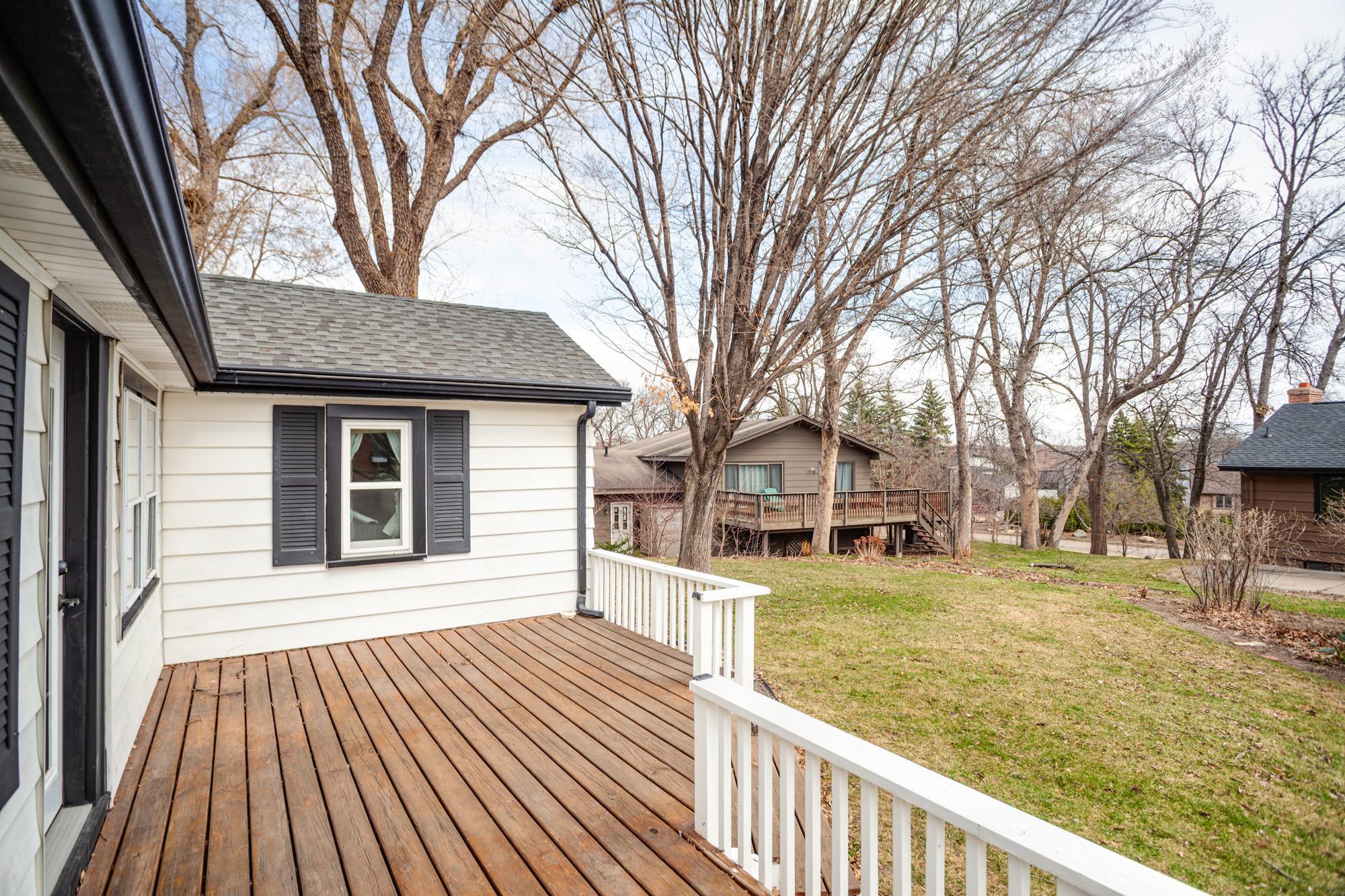 The deck overlooks the flat, manicured yard.