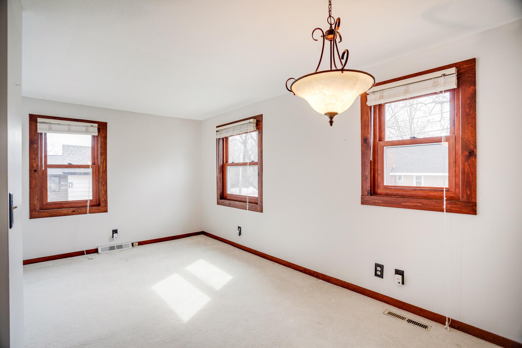 Dining area wrapped in light with neutral decor and a central light.