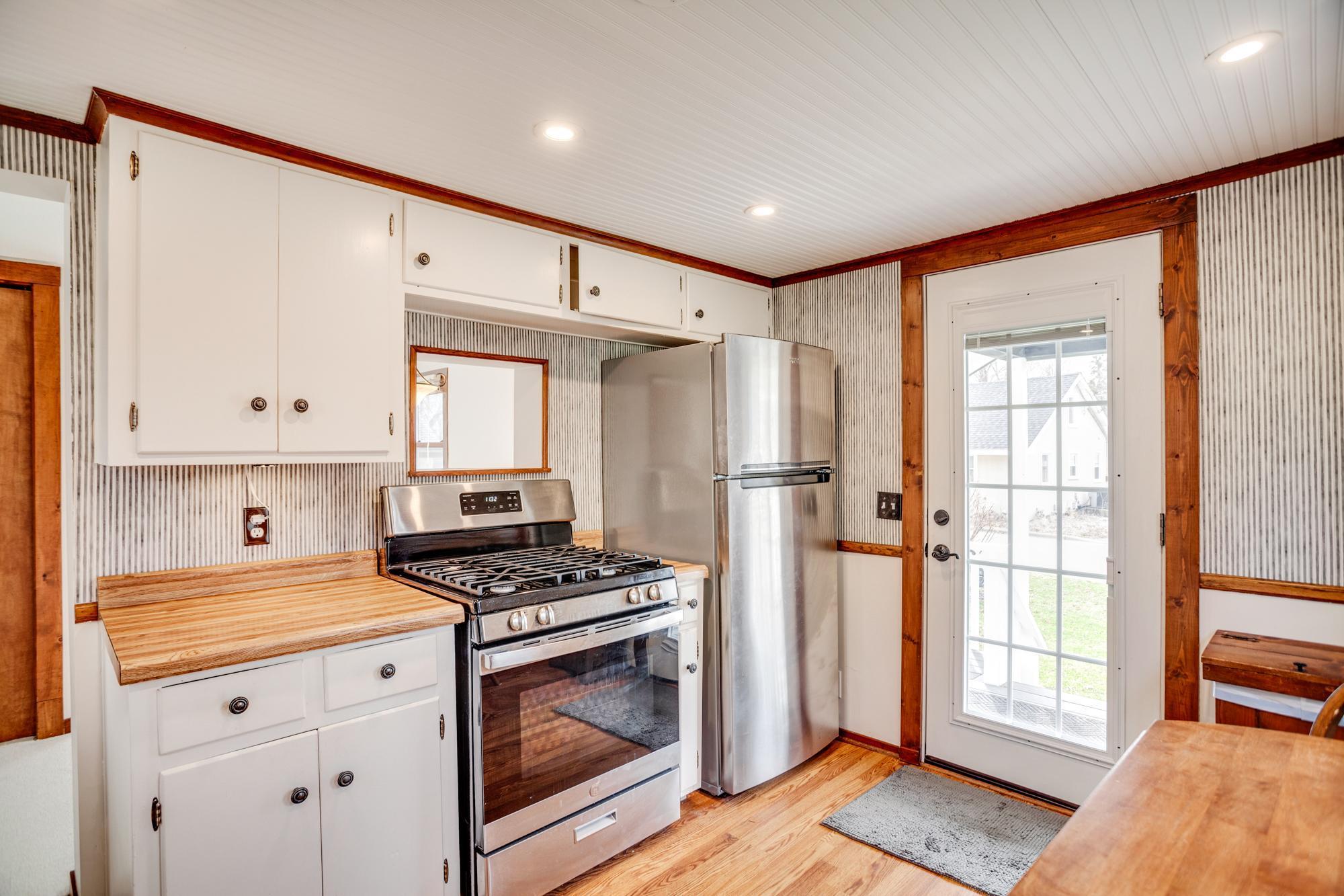 Stainless steel gas range/oven and refrigerator.