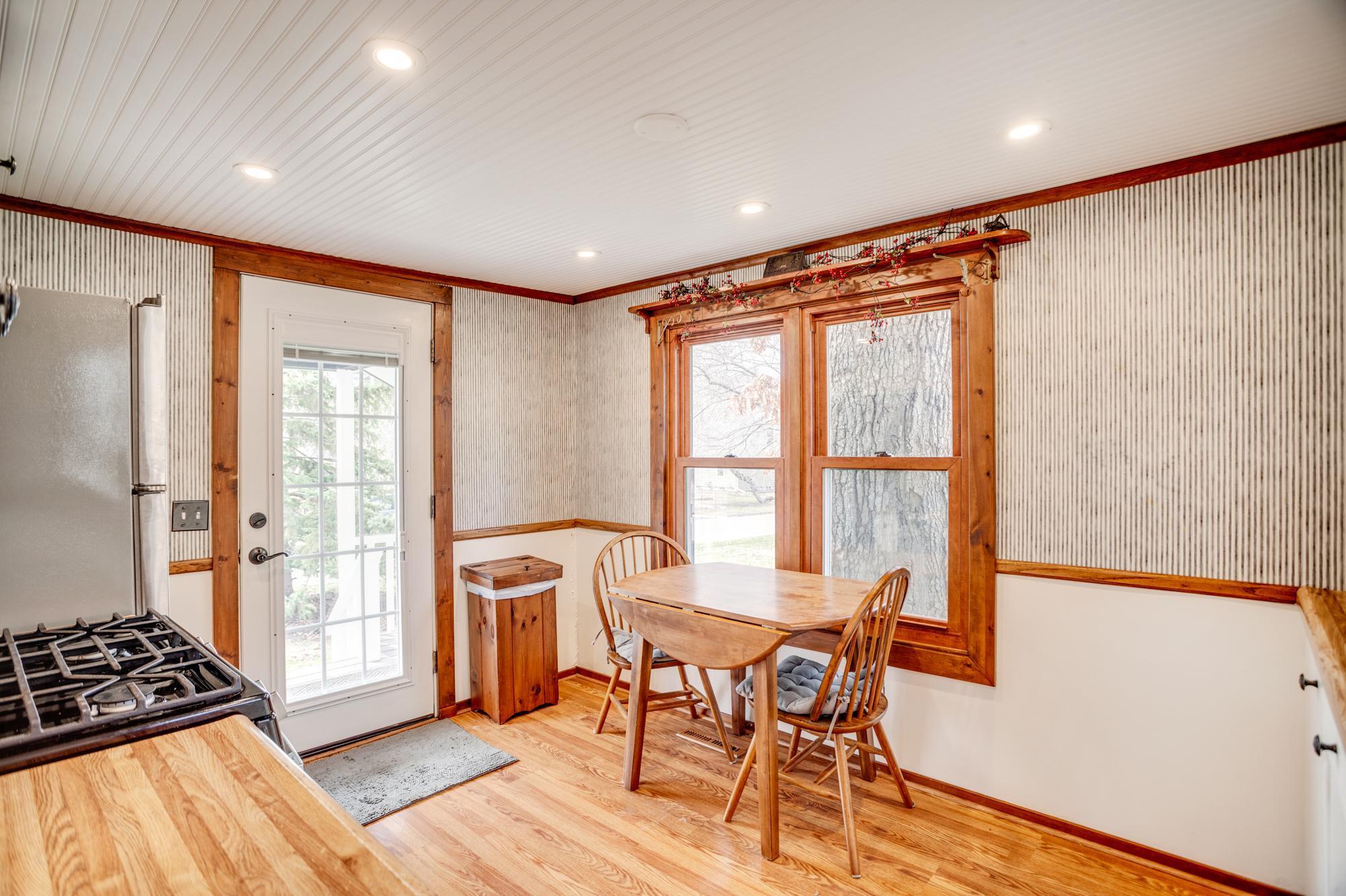 Sunny informal dining niche within the kitchen. The front door/porch of the home leads directly into the kitchen area.