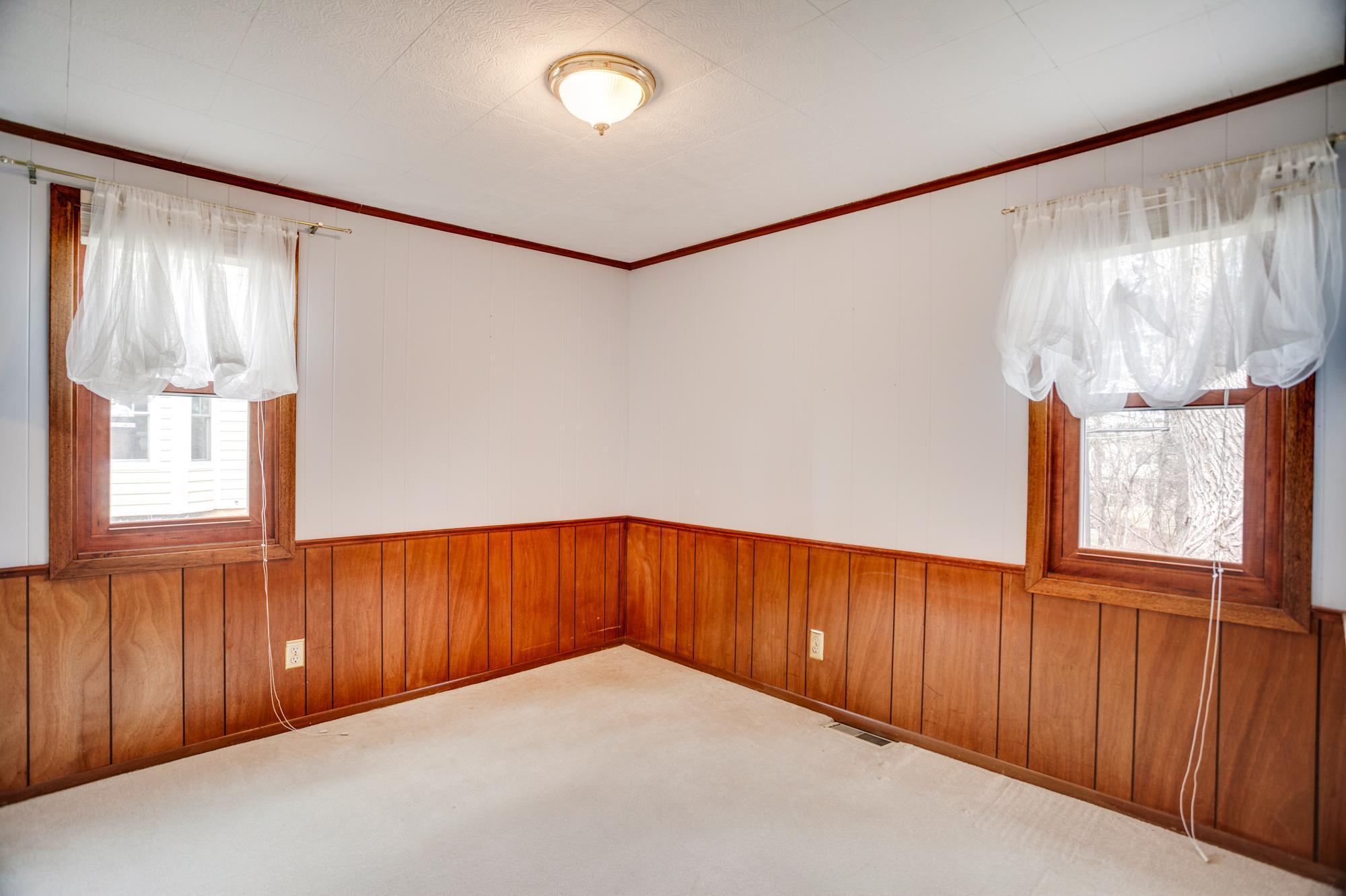 Bedroom 2 features wood panel chair rail and crown molding ceiling accents.
