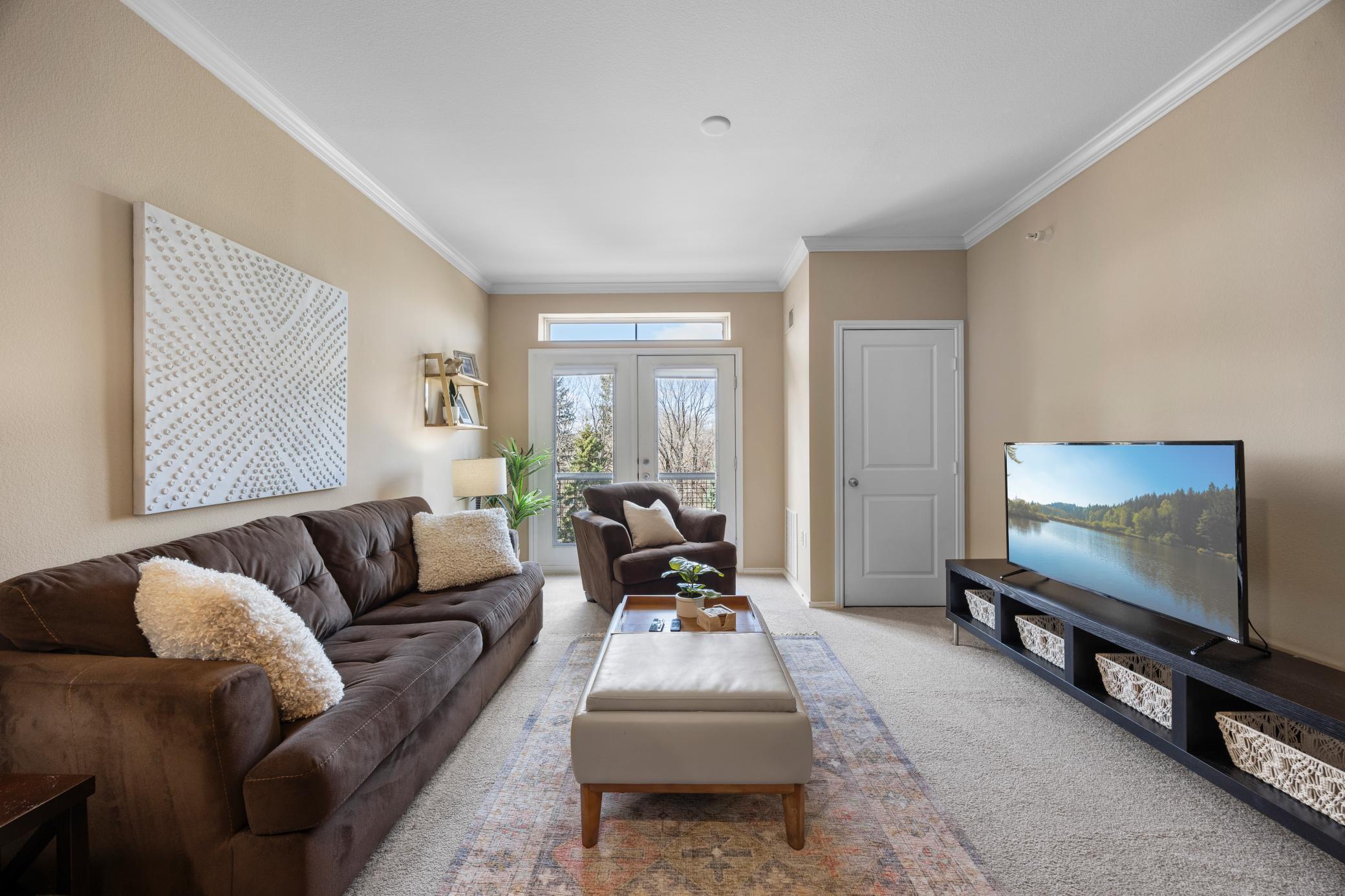 Great view of the living room - this home has a balconette so you can step outside and decide what kind of Minnesota day it is - sweater weather or summer weather.