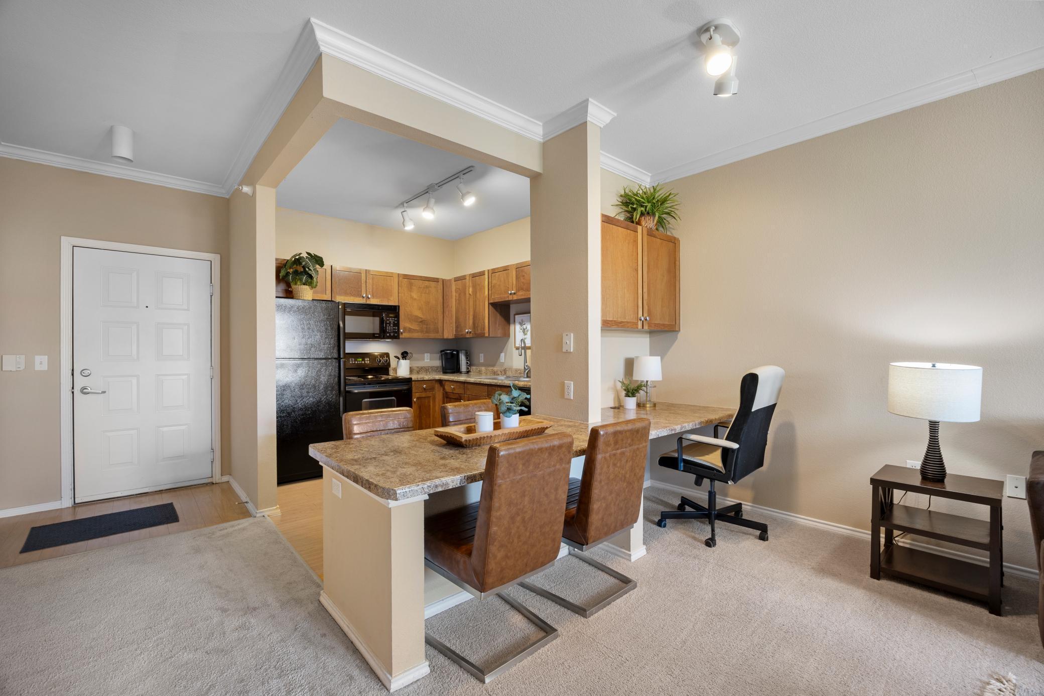 A nice view of your entrance, desk, dining area and kitchen.