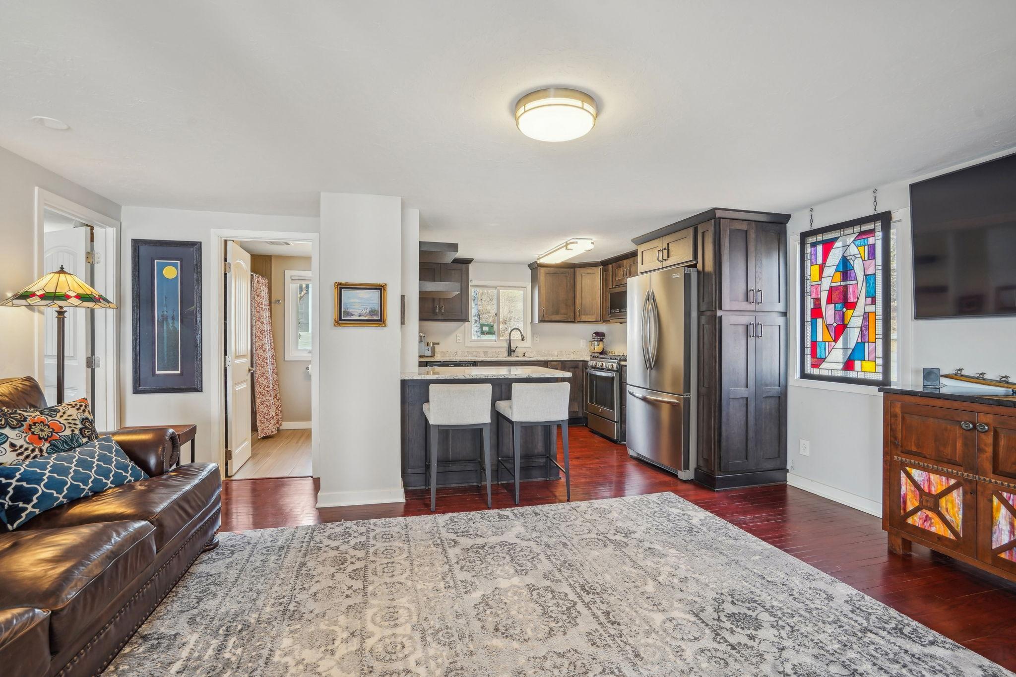 The interior boasts updated finishes, including gleaming hardwood floors, a modern updated kitchen with stainless steel appliances.