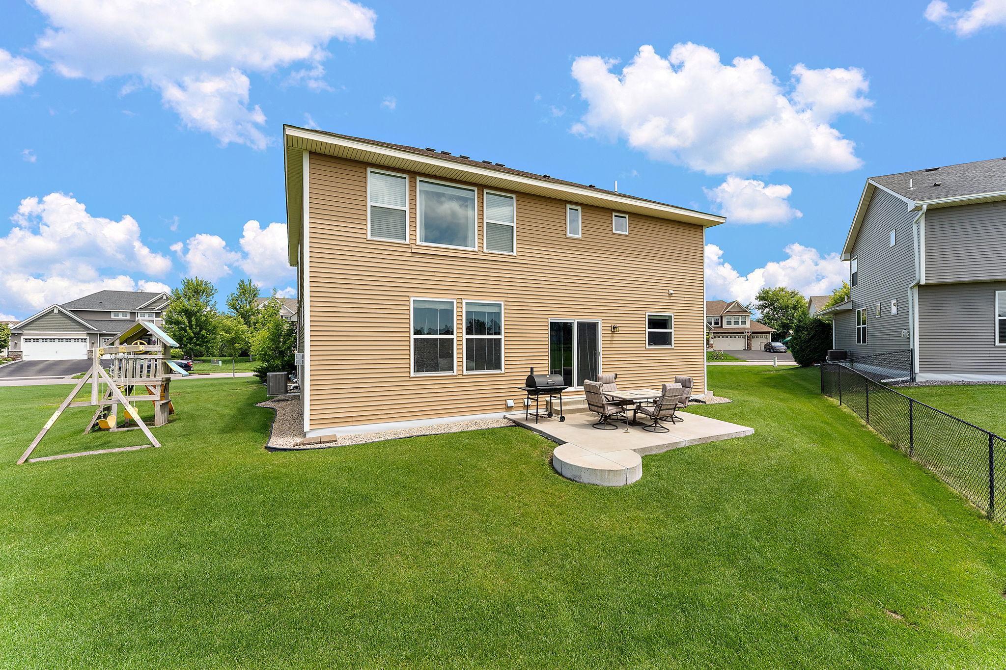 Backyard shows cement patio and playlet