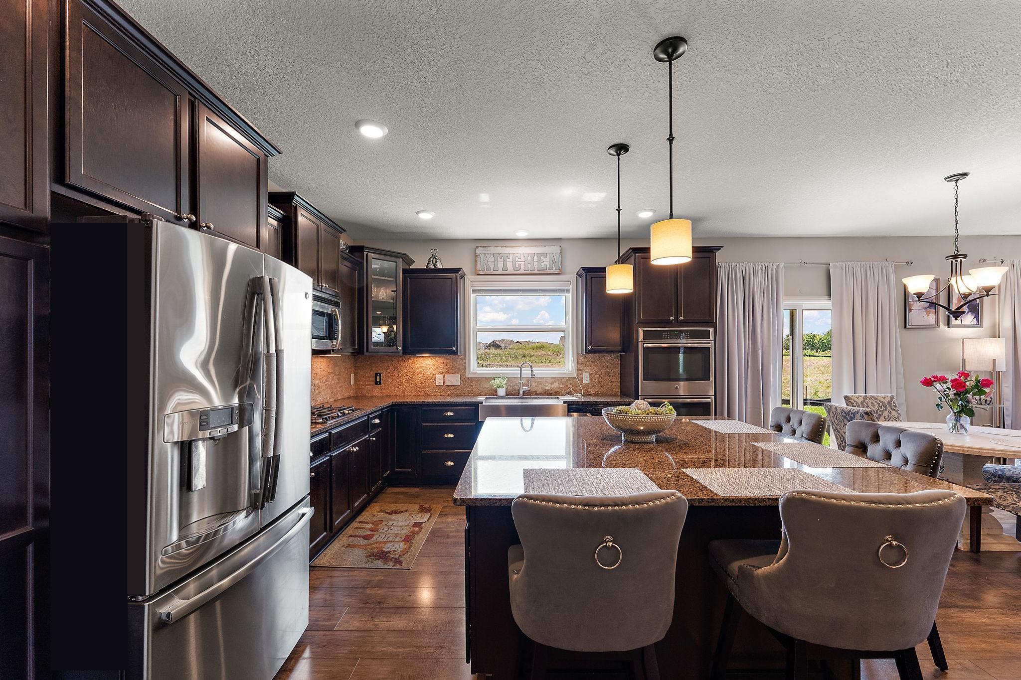 Amazing kitchen has everything you want! Farm sink, huge granite island, incredible storage, stone backsplash, under counter lights and more!