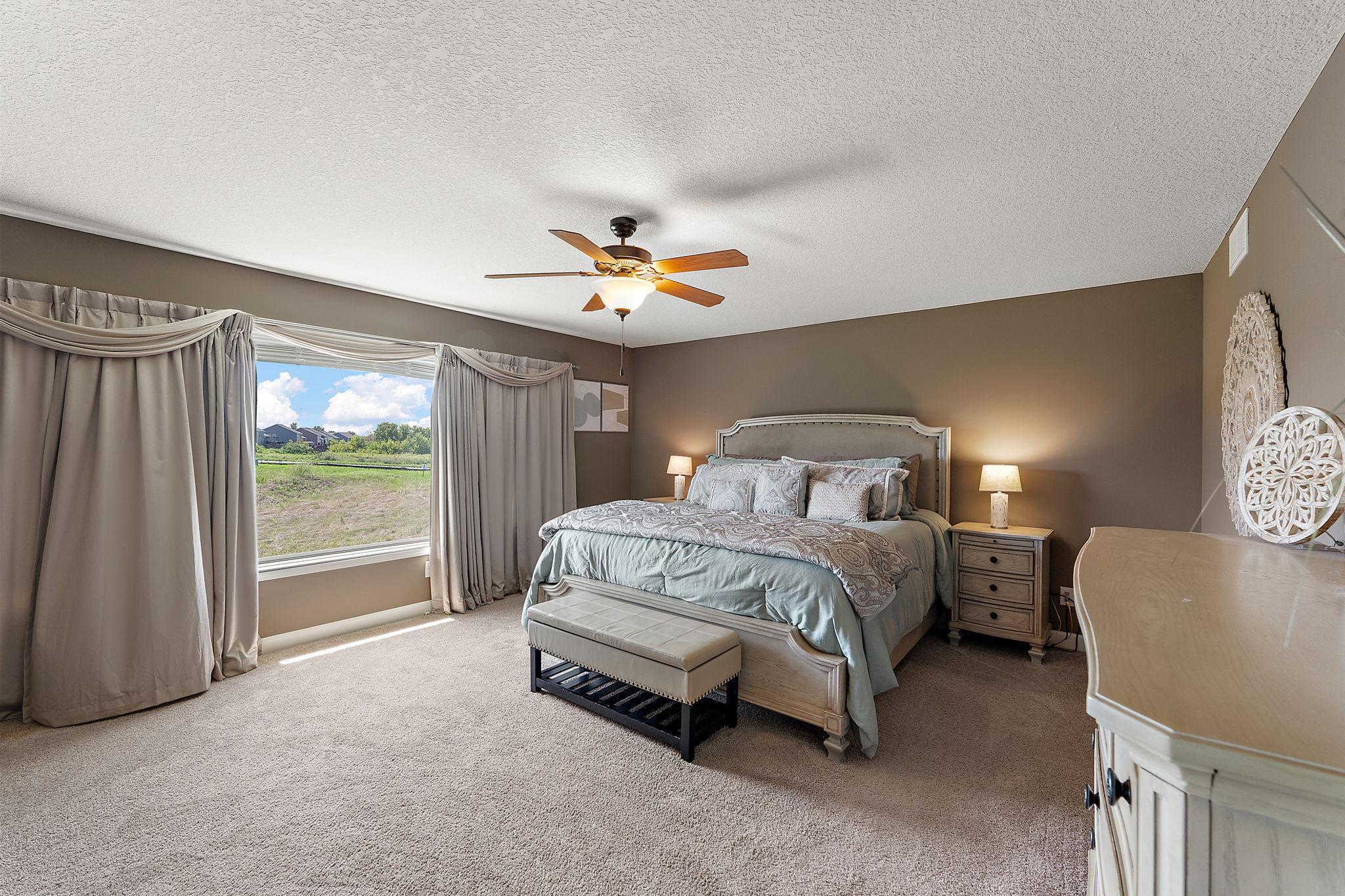 Primary suite has large picture window, spacious room, and private bath