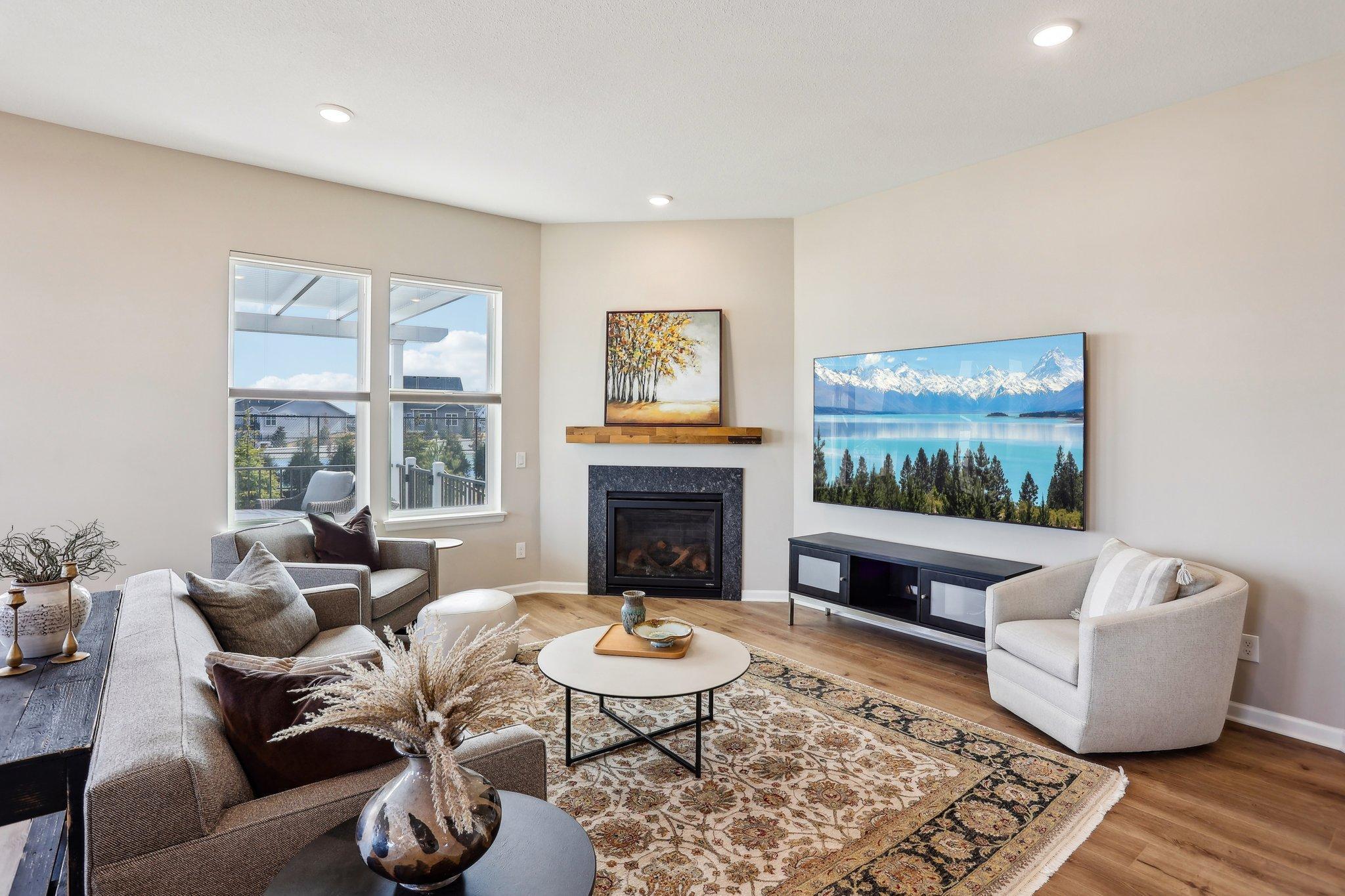 The living space is filled with natural light and features a cozy fireplace.