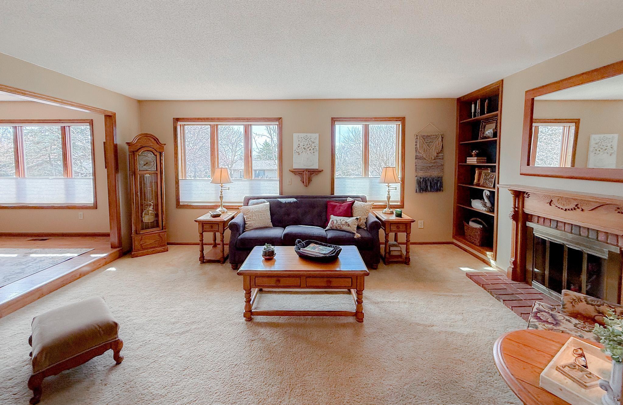 Living room area features wood burning fireplace, custom surround and custom built-ins on each side
