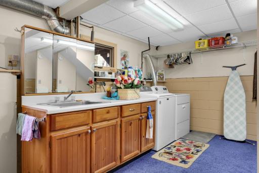 Basement laundry with utility sink & abundant storage options.