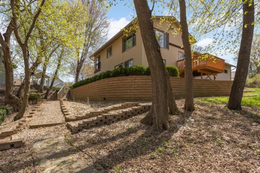 Professionally designed custom retaining wall wraps around back of home.
