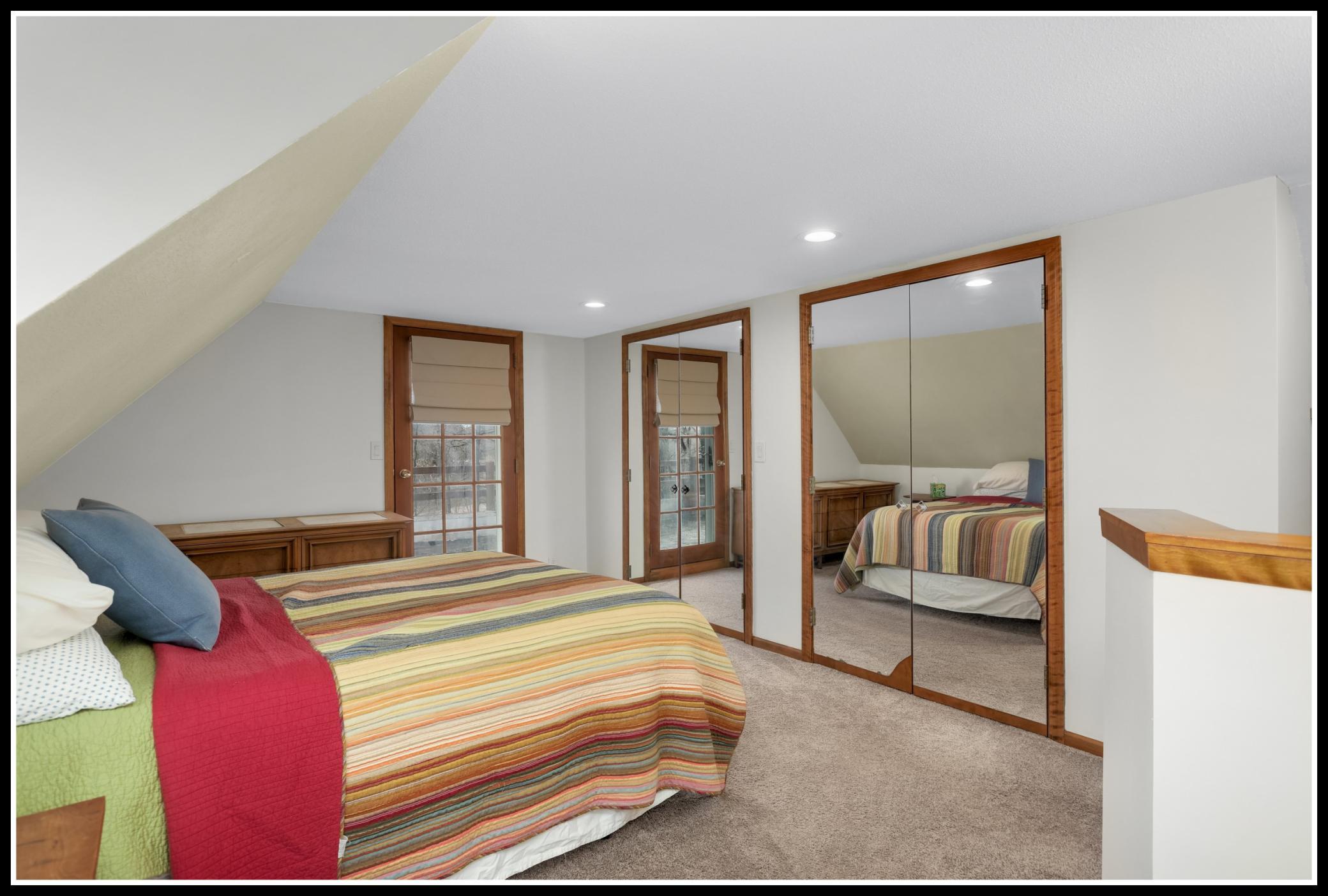The primary bedroom on the upper level includes double closets and access to a balcony