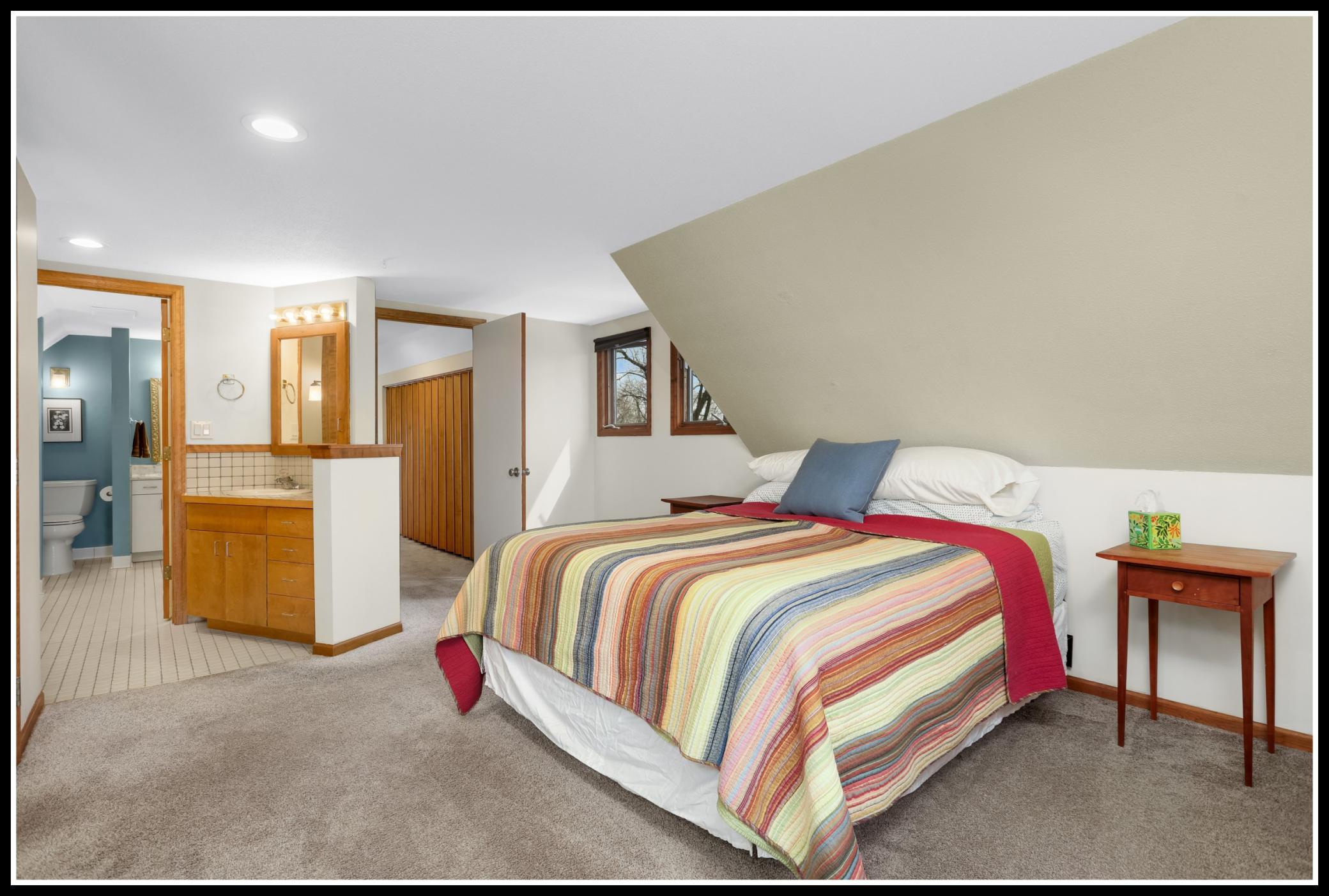 Primary bedroom has walk-through access to the upper level bathroom and includes a separate vanity