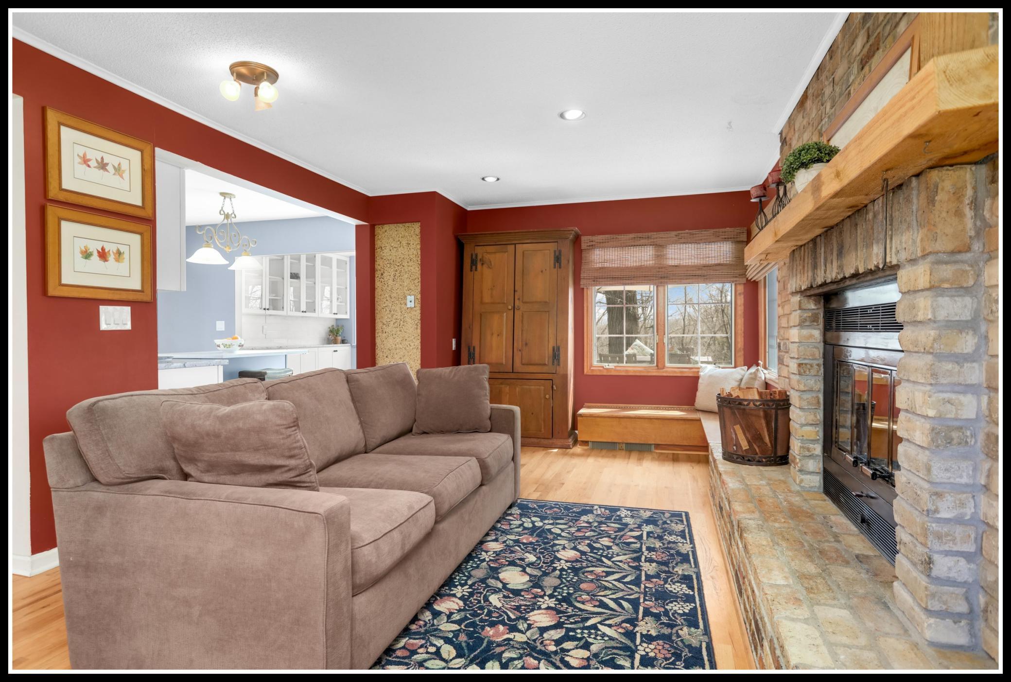 Corner windows and built-in window seats with storage flank the fireplace
