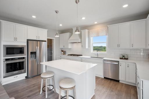 Entertain in your gourmet kitchen with high end KitchenAid appliances. Photo of prior model home, colors and finishes will vary.
