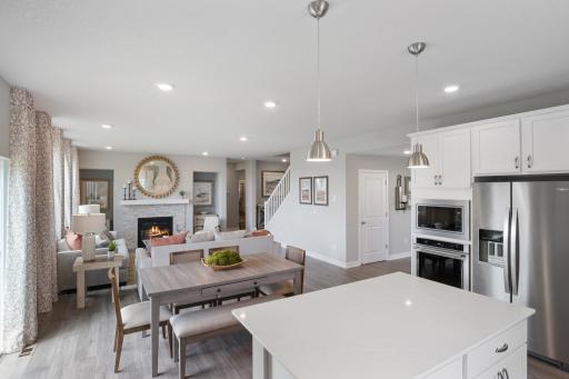 Kitchen opens to the rest of the main living space. Photo of prior model home, colors and finishes will vary.