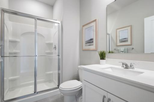 Main floor ensuite bathroom. Photo of prior model home, colors and finishes will vary.