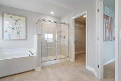 Primary Bathroom with soaking tub and separate shower. Photo of prior model home, colors and finishes will vary.