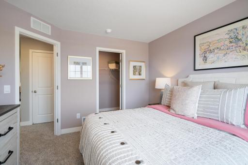 Upper level bedroom 2, another view. All bedrooms include a walk in closet. Photo of prior model home, colors and finishes will vary.