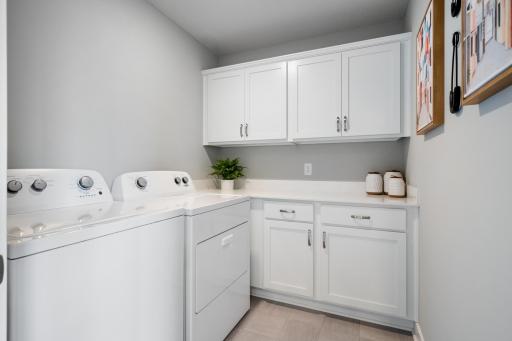 Upper level also offers a large laundry room with cabinets! Photo of prior model home, colors and finishes will vary.