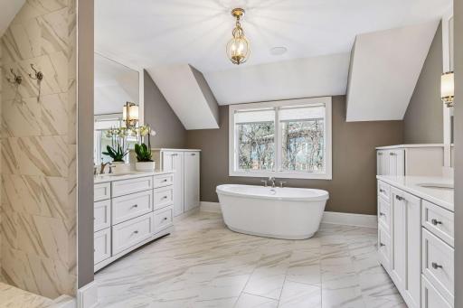 The spa like owner's bath has dual vanities, gorgeous tiling and a soaking tub