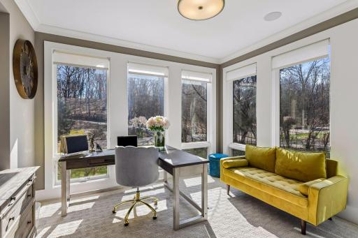 The warm and inviting office has floor to ceiling windows on three sides