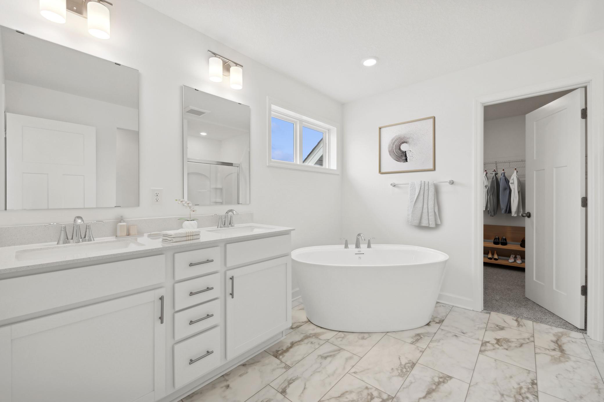 (Photo of a decorated model, actual homes finishes and colors will vary) The primary bath includes a double vanity, a soaking tub, and a separate shower.