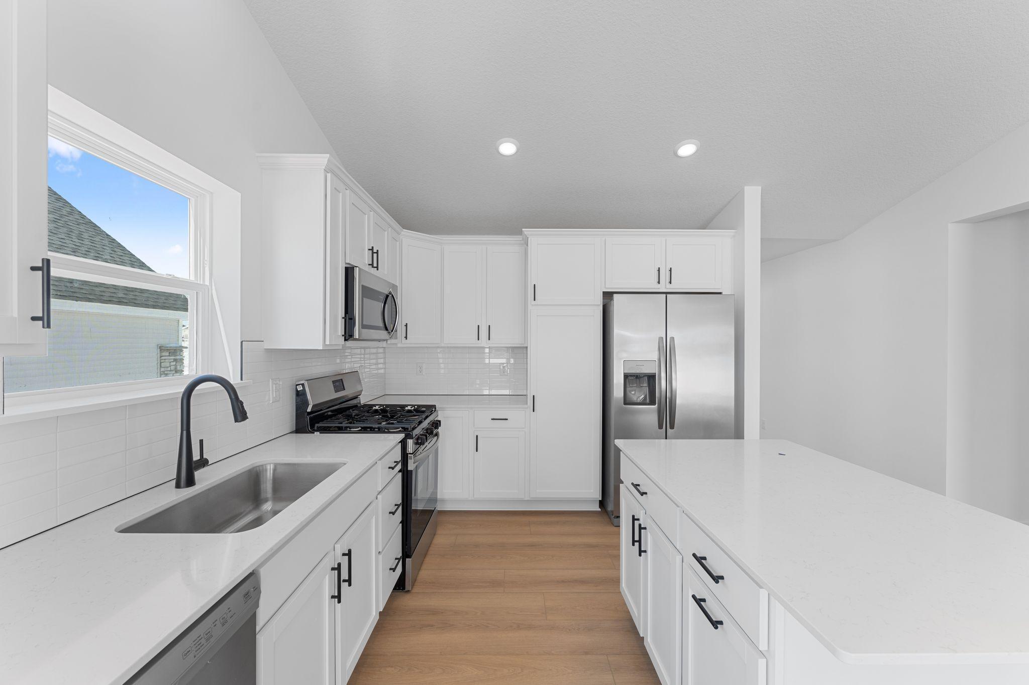 The chef-inspired kitchen showcases an elevated design, equipped with new cutting-edge appliances and a center island that adds bar-style seating.