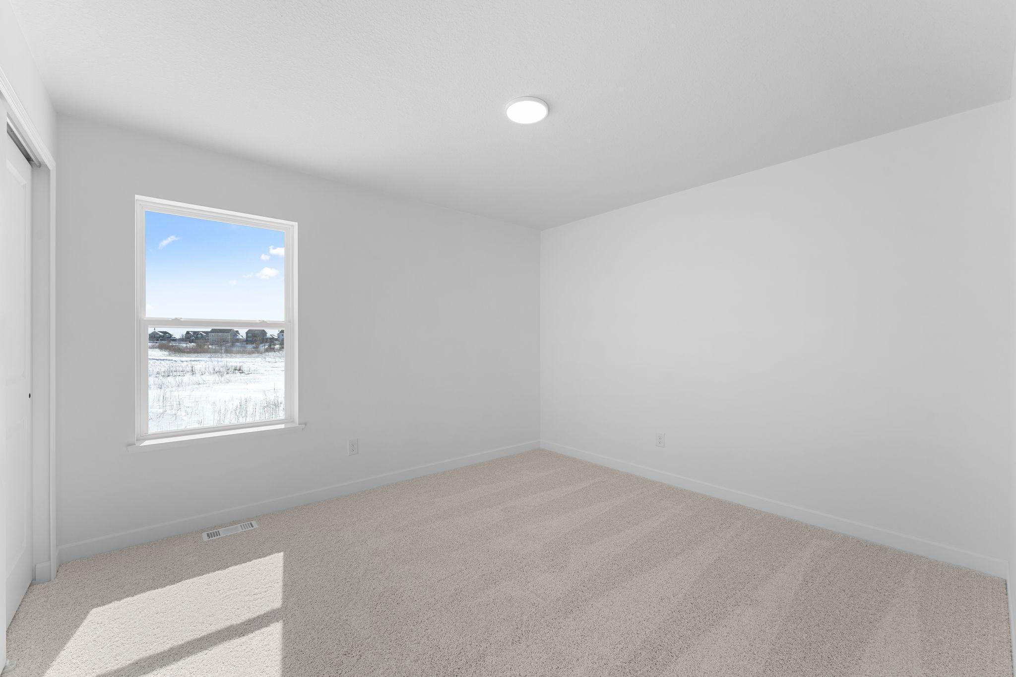 Two secondary bedrooms are located in a rear corner of the home, providing peaceful havens.