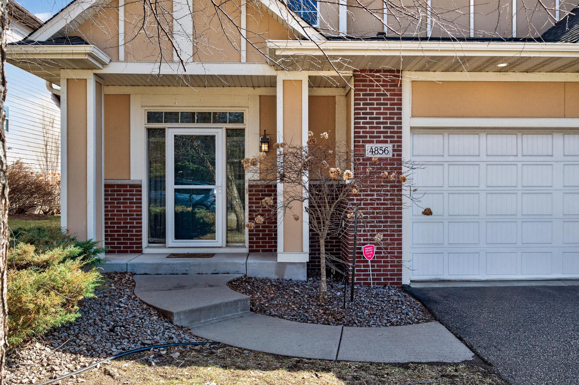 Beautifully maintained front elevation with a private entry, curved walkway, and low-maintenance landscaping. The exterior blends warmth, character, and everyday functionality.