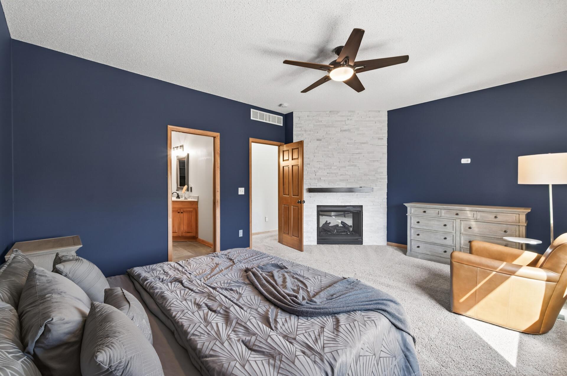 Expansive primary bedroom with plush carpeting, rich accent walls, and large windows that bring in natural light. Offers ample space for a full furniture set and comfortable retreat.