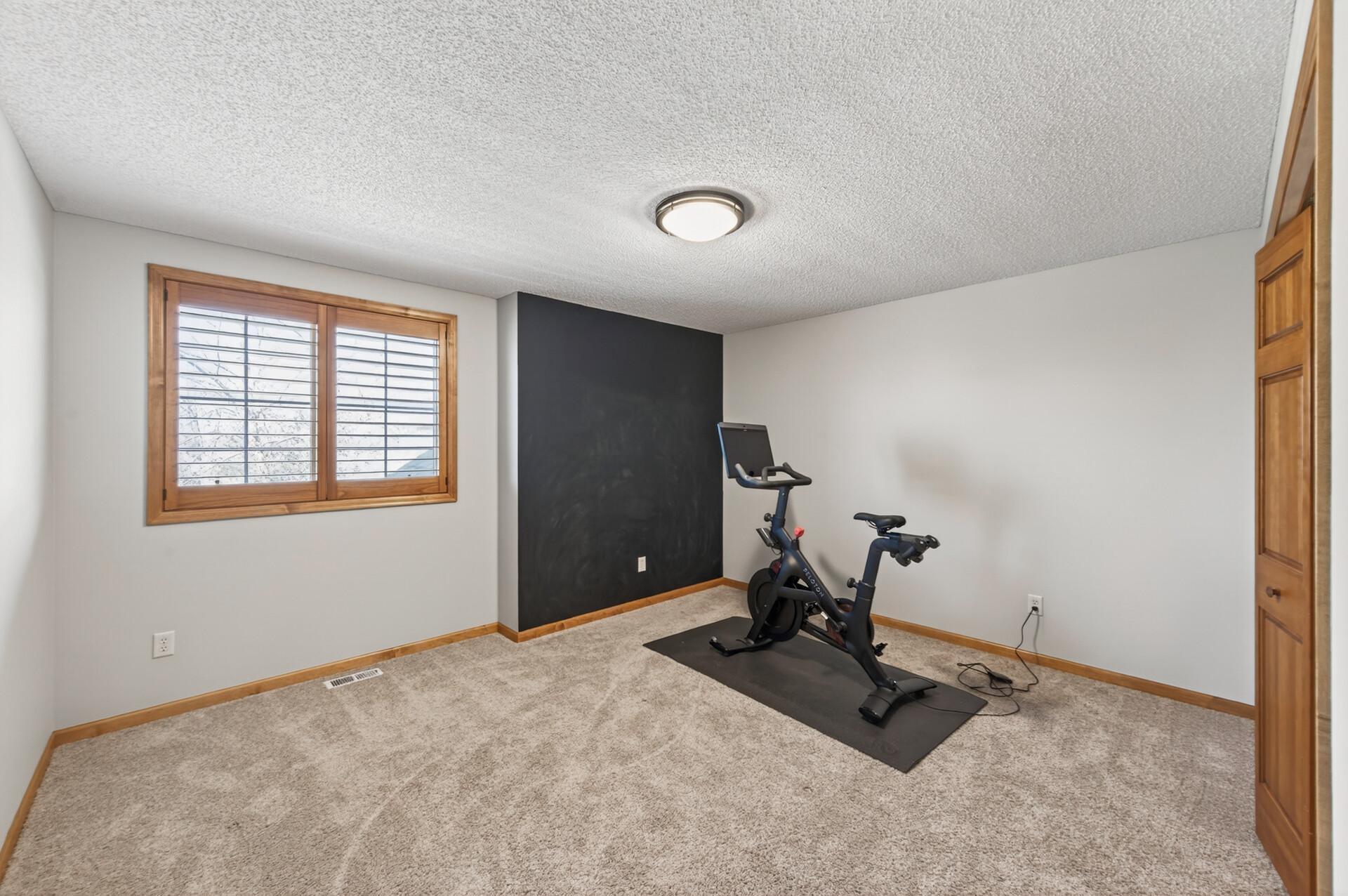 Bright 3rd bedroom/flex room, ideal for a home office, fitness space, or guest room with versatile functionality.