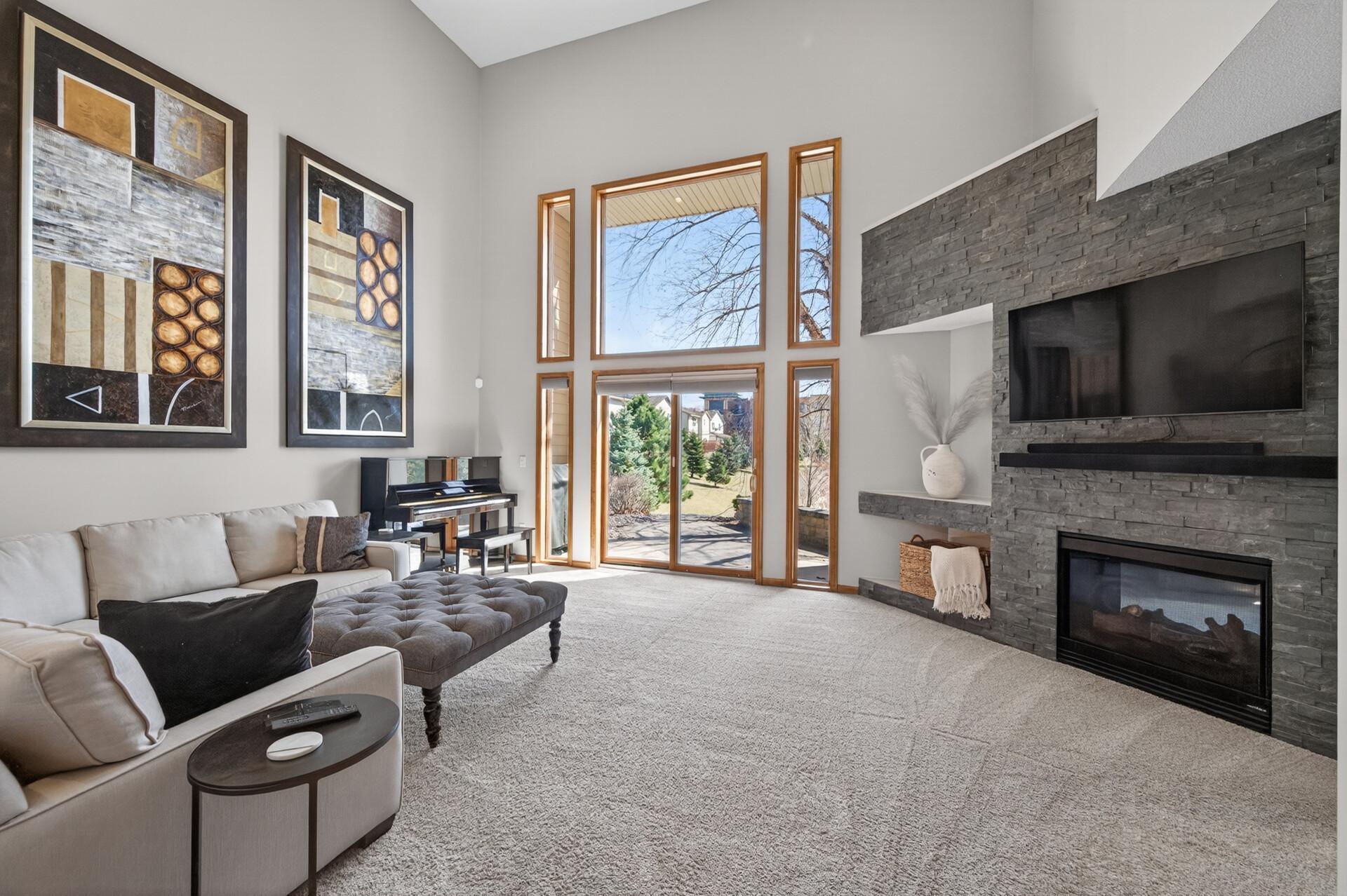 Welcome to 4856 Grandview Ct; this expansive living room features soaring ceilings and dramatic floor-to-ceiling windows, filling the space with natural light. Enjoy direct access to the outdoor patio, perfect for relaxing or entertaining.