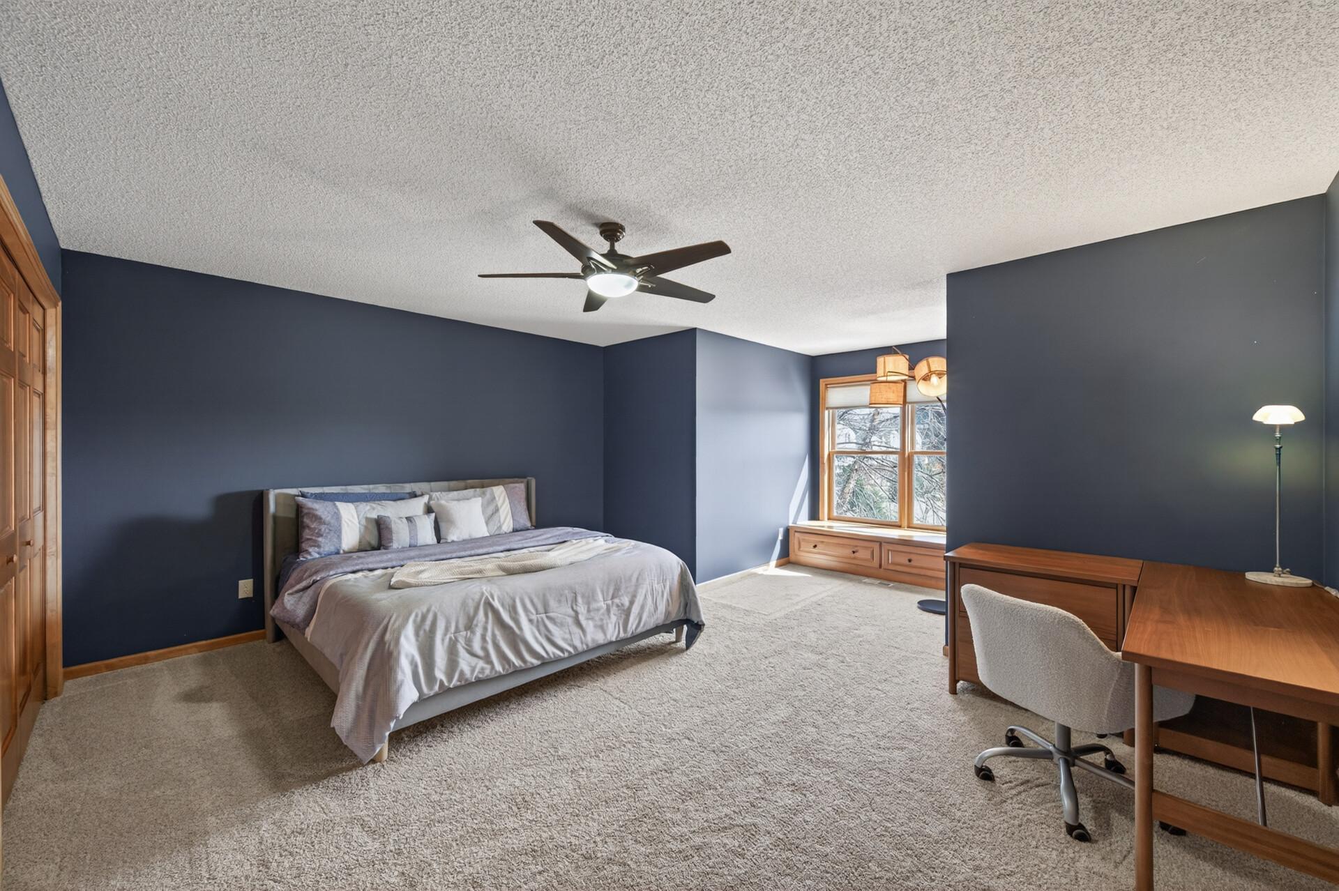 Generously sized bedroom with soft carpeting, large window, and plenty of natural light. Ideal for guests, family, or a flexible home office setup.
