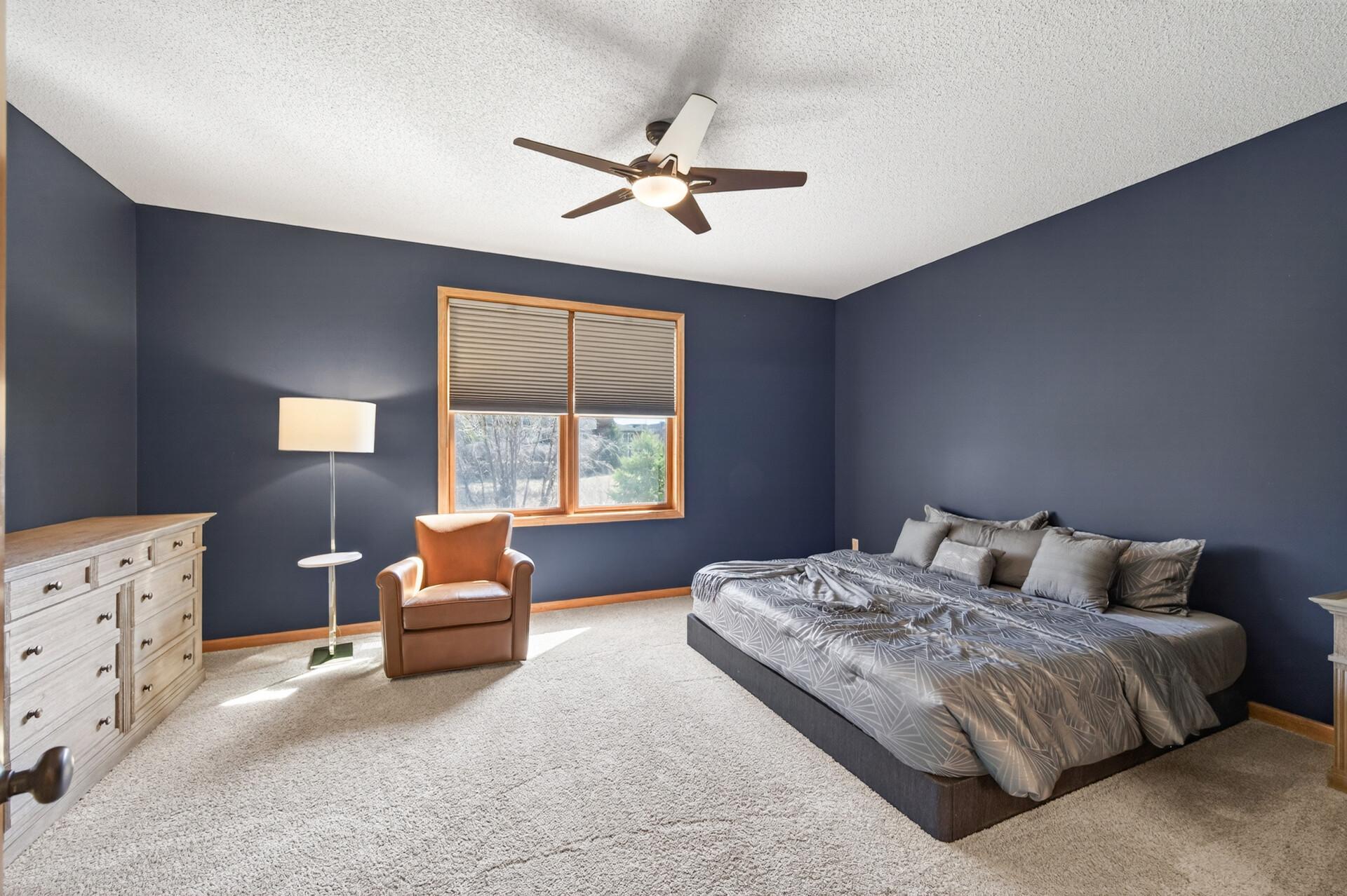 Another view of the generously sized primary suite showcasing a cozy fireplace feature wall and flexible layout options. Ideal for creating a relaxing, private sanctuary.