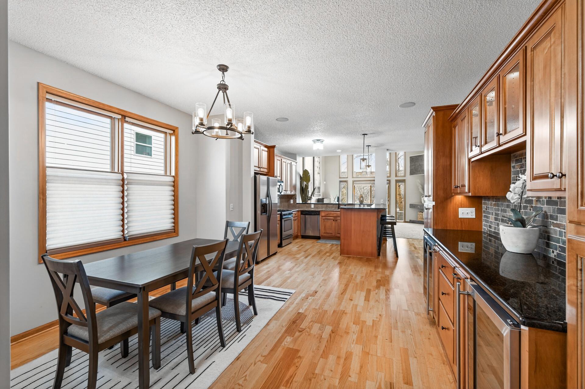 Open-concept kitchen and dining area filled with natural light and warm wood finishes. The layout offers excellent flow for both everyday living and entertaining.
