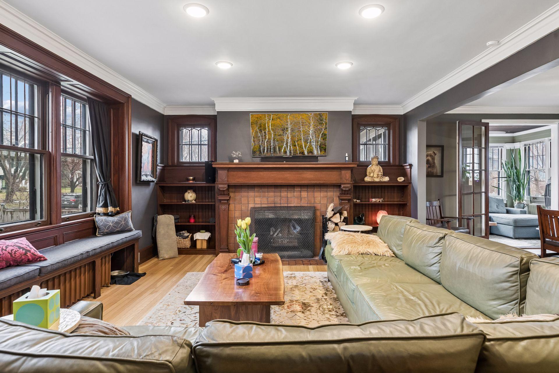 Living room with woodburning fireplace - in 2021 the chimney cap, brickwork, liner were all redone - fireplace in living room and primary bedroom are both woodburning - hardwood floors revarnished every two years