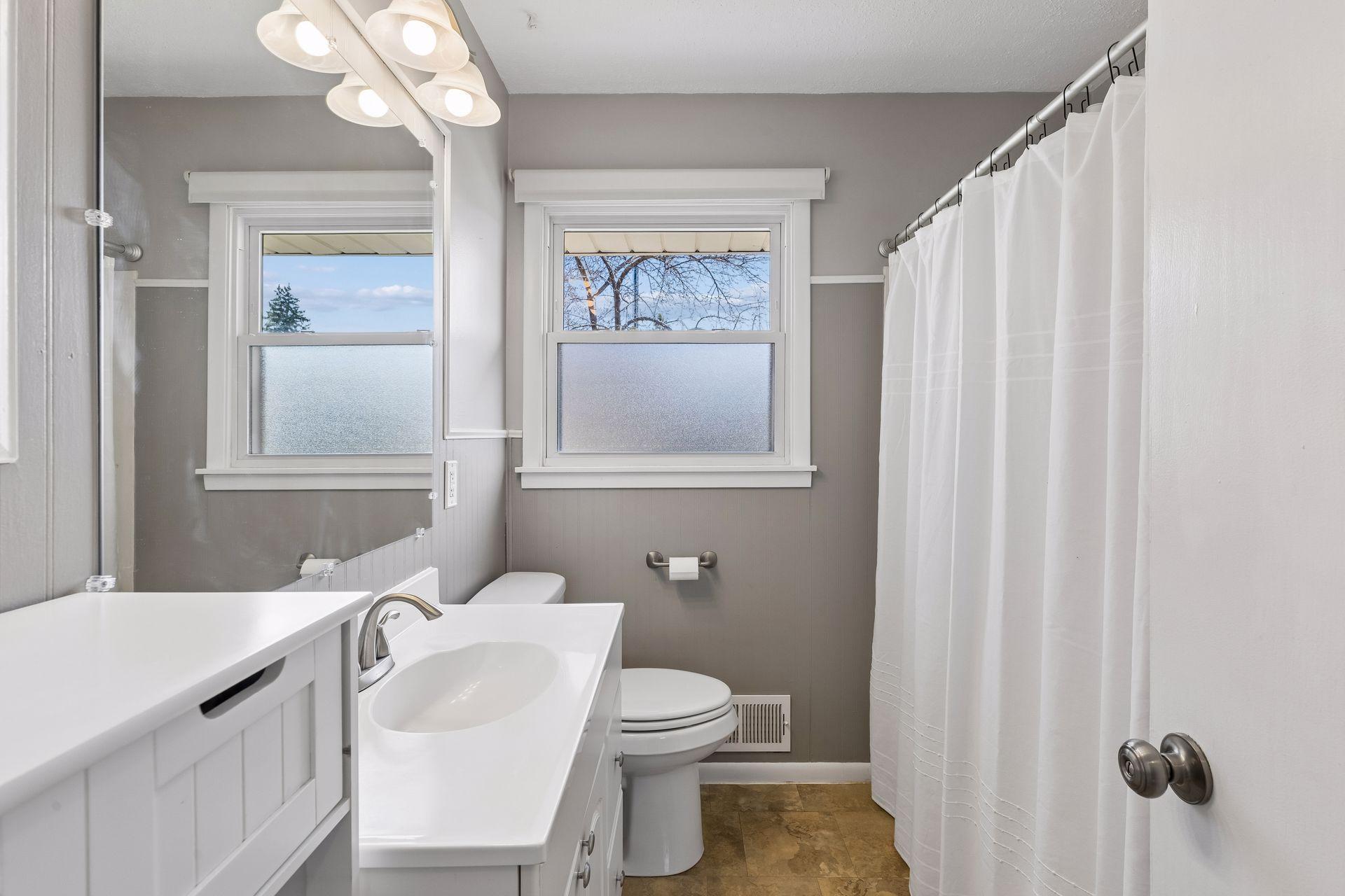 Updated full bath with oversized vanity, great natural light, and functional layout.