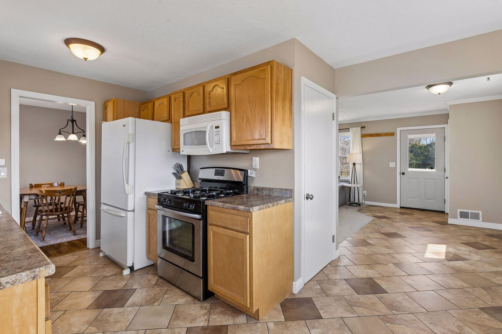 Seamless flow from kitchen to dining and entry spaces, highlighted by continuous tile flooring and an open, easy-living layout.