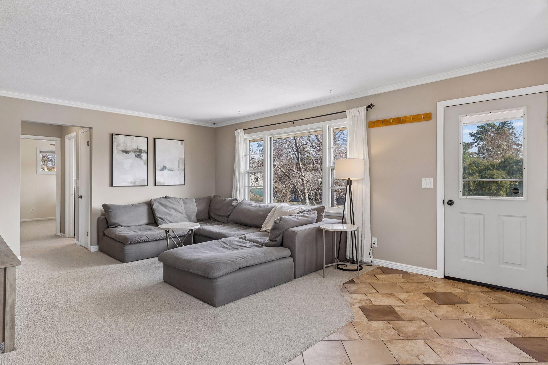 Bright and inviting living room with large windows, abundant natural light, and easy flow to the entry and adjacent spaces.