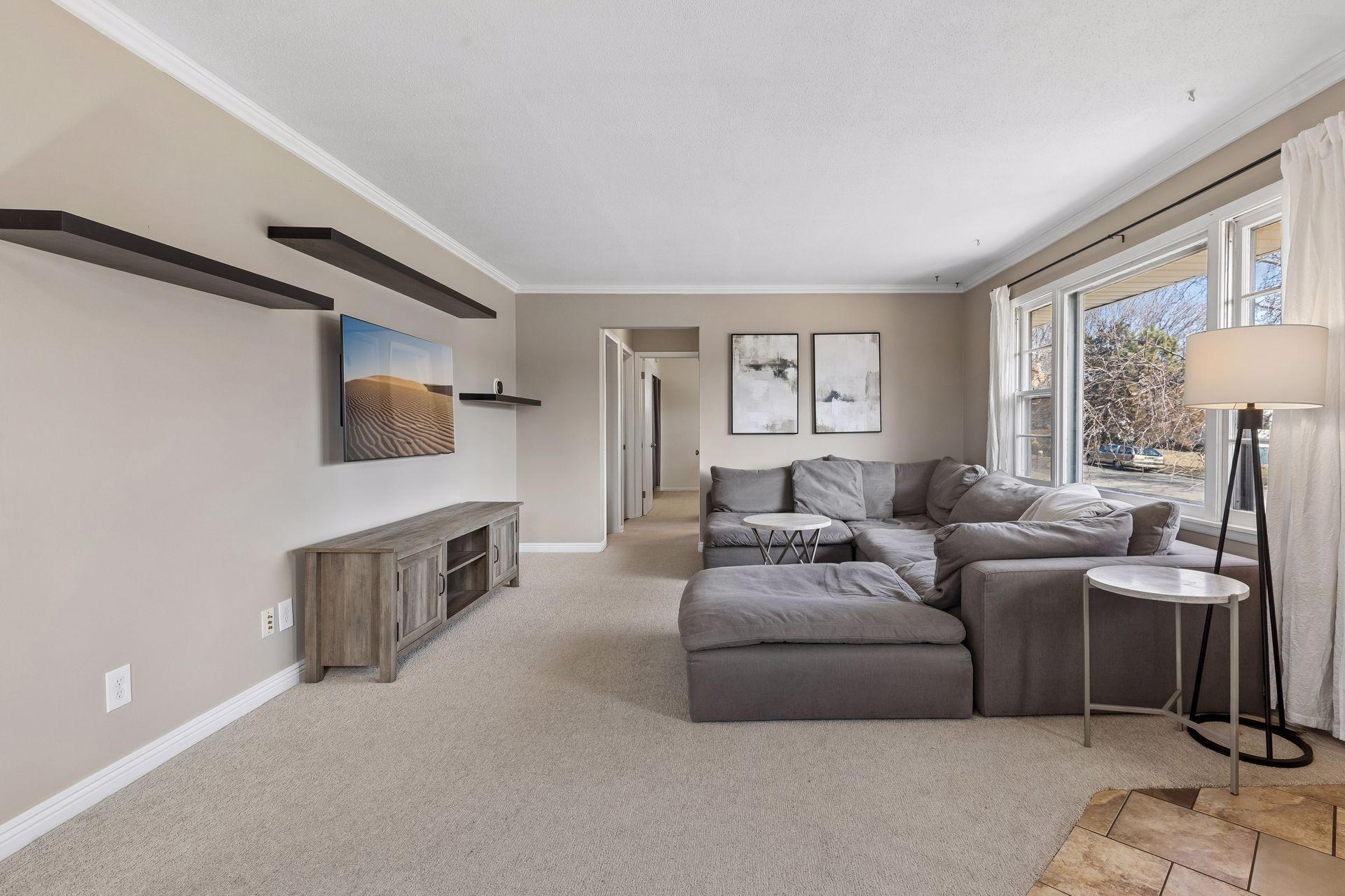 Spacious living area with comfortable layout, built-in display shelving, and easy access to the bedroom wing.