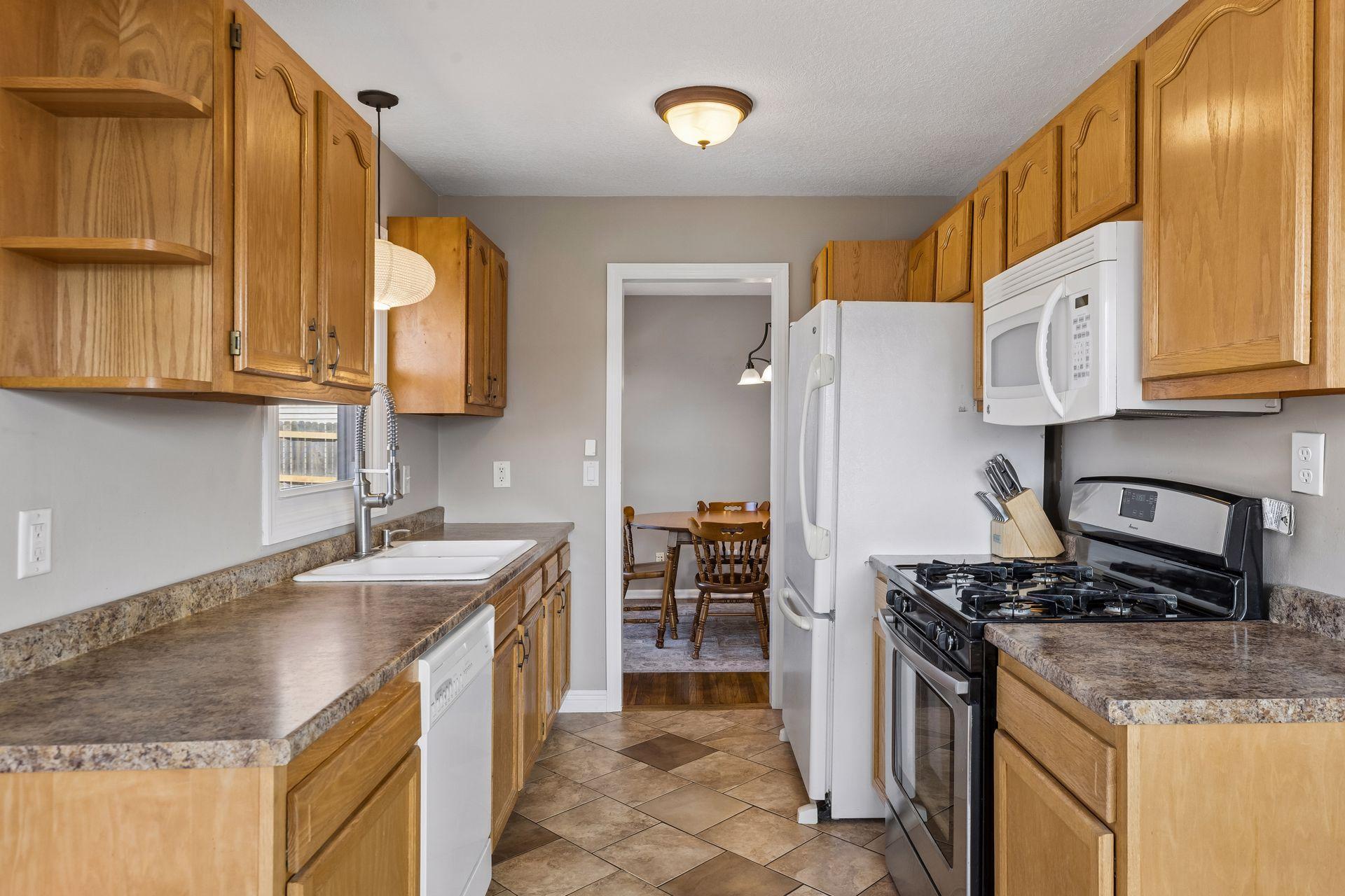 Well-designed kitchen featuring tile floors, generous cabinet storage, and a practical layout with seamless access to the dining area.