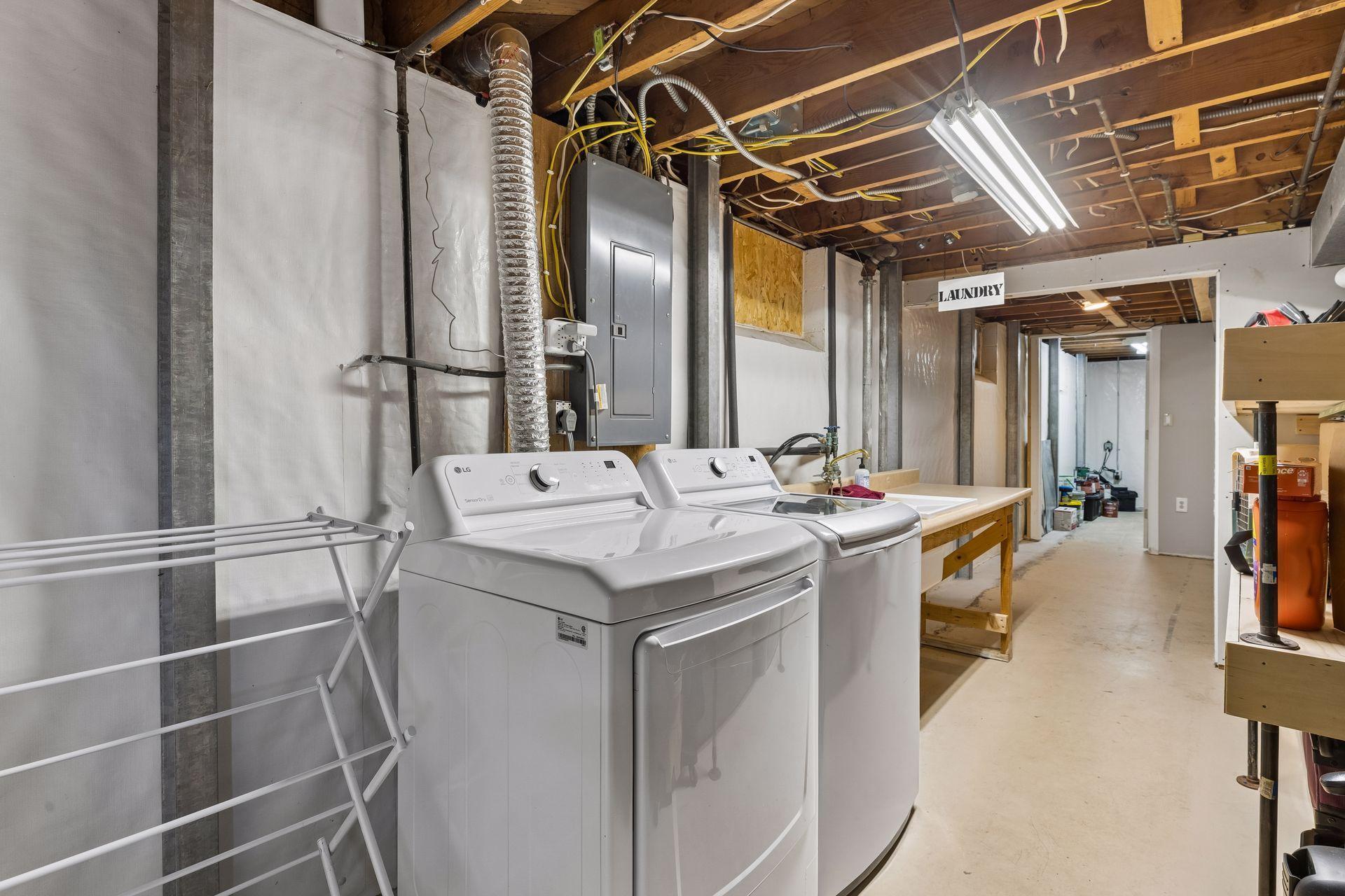 Spacious laundry and utility area featuring a sink, workbench, and plenty of room for storage and projects.
