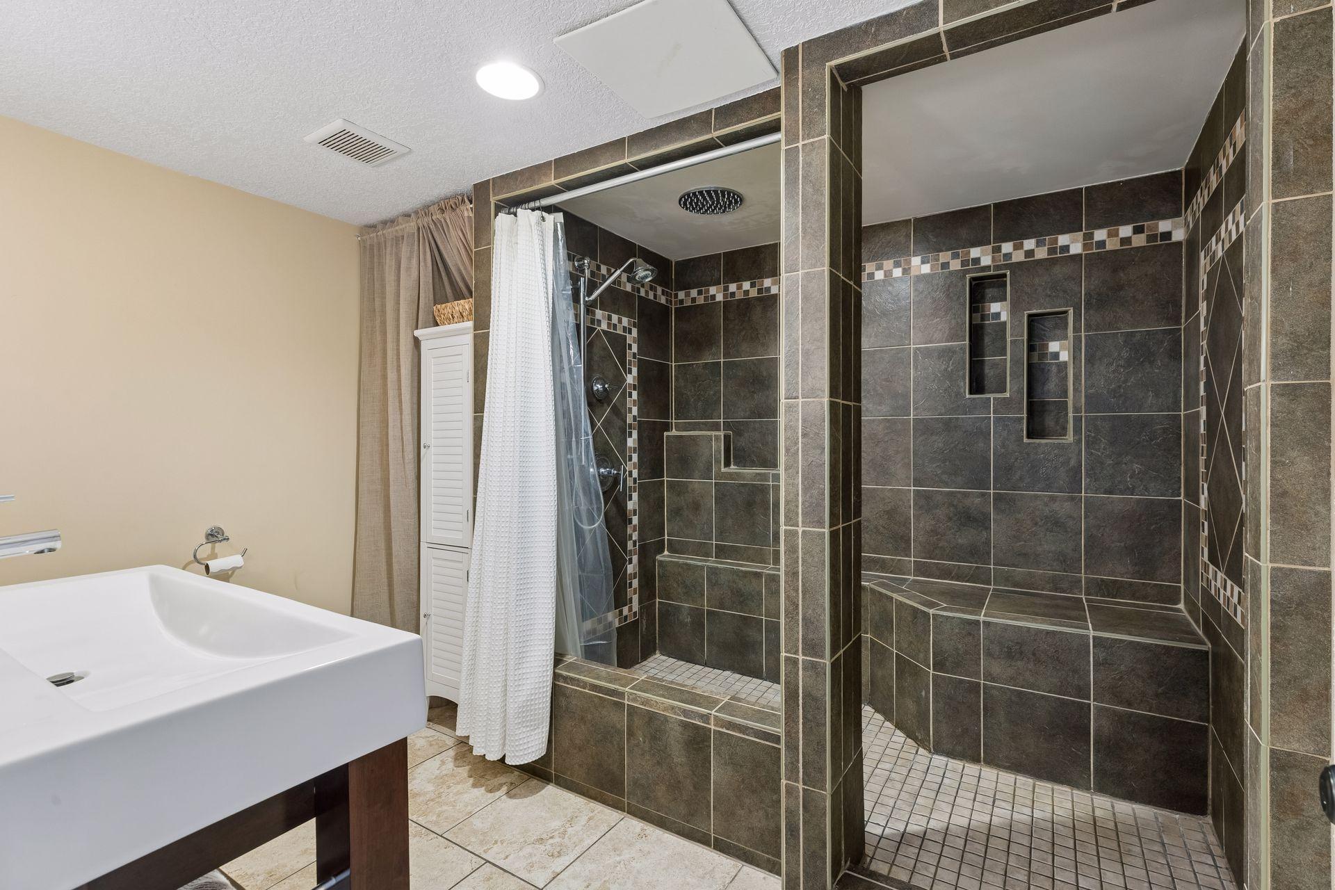 Stunning ¾ bath showcasing a custom tiled walk-in shower with bench seating and designer tile details.