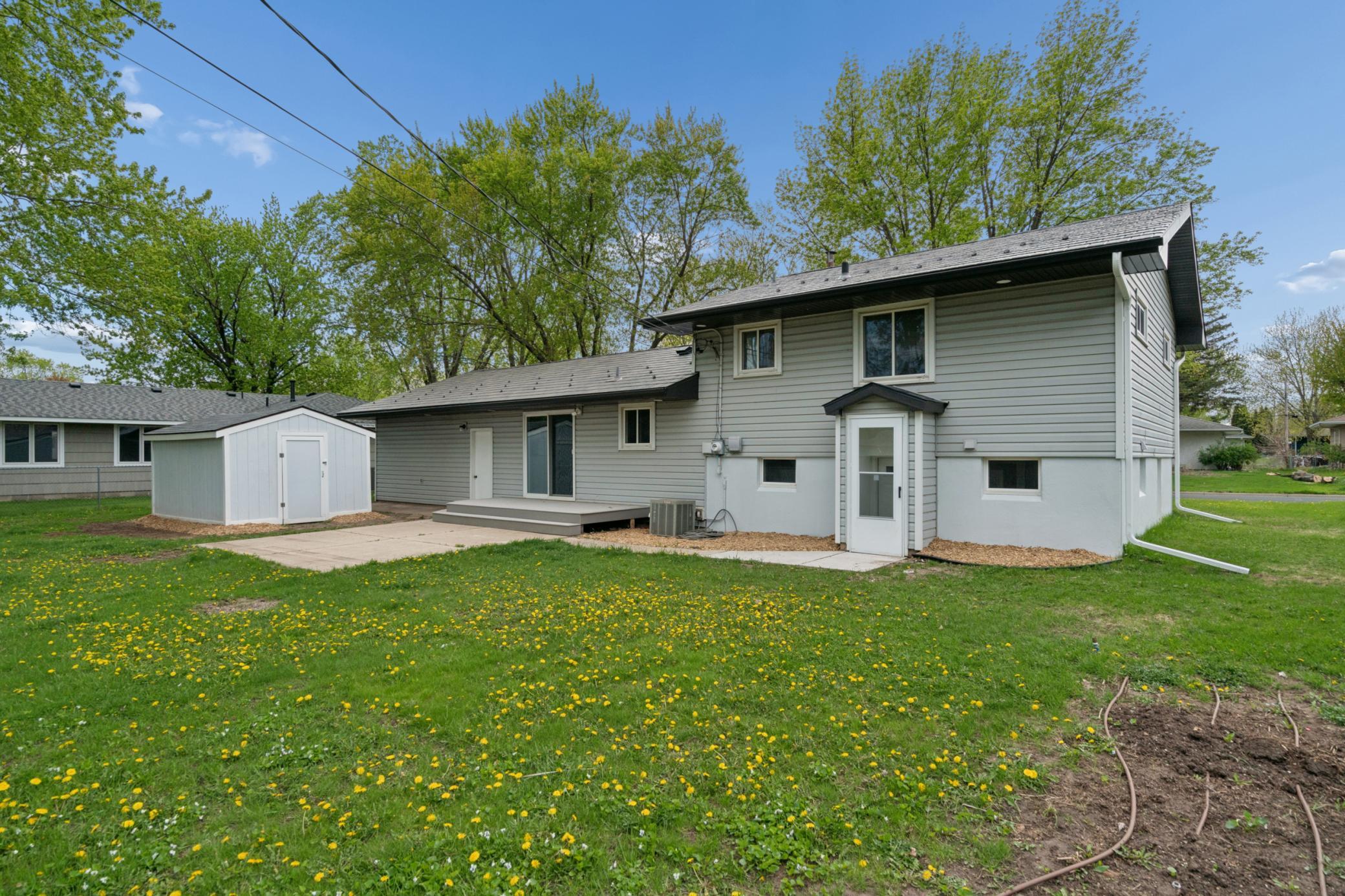 Rear of Home with 3 doors to Garage, main and lower levels