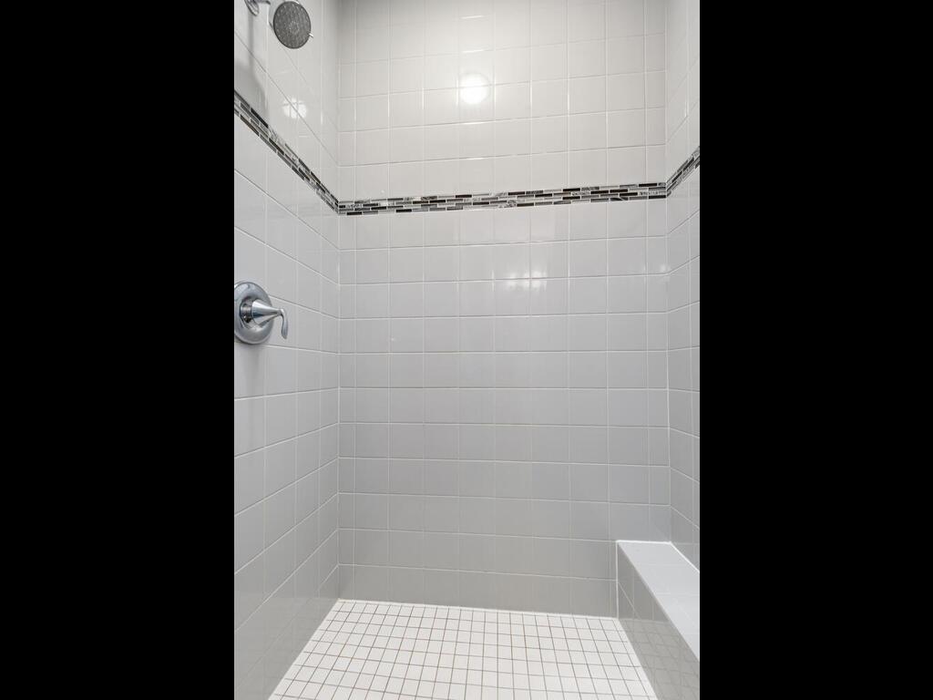 Walk-in tile shower with built-in bench and clean, modern finishes.
