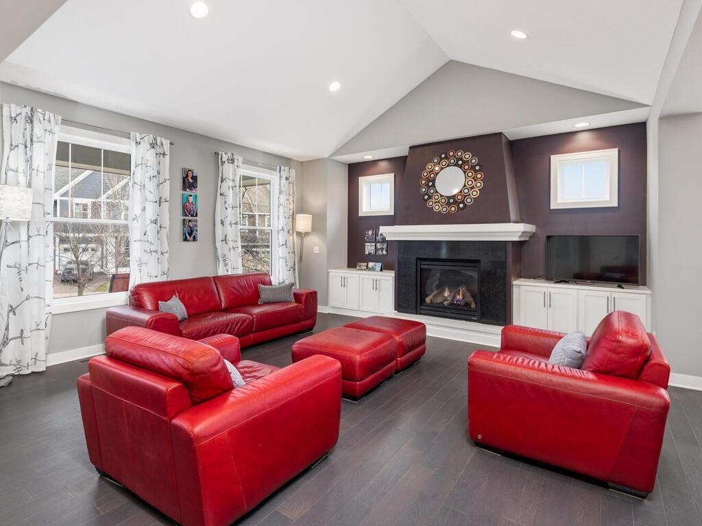 Open living room with vaulted ceilings, large windows, and gas fireplace.