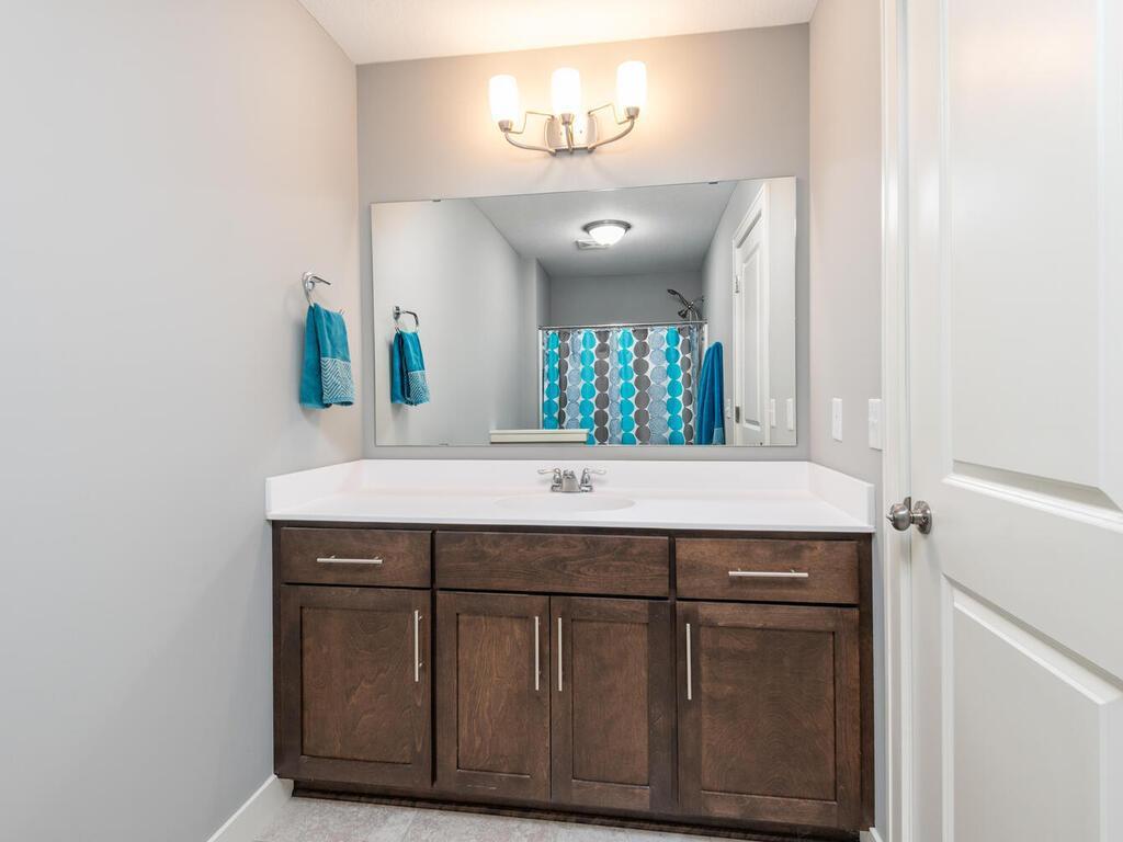 Full bathroom with large vanity, ample storage, and bright lighting.