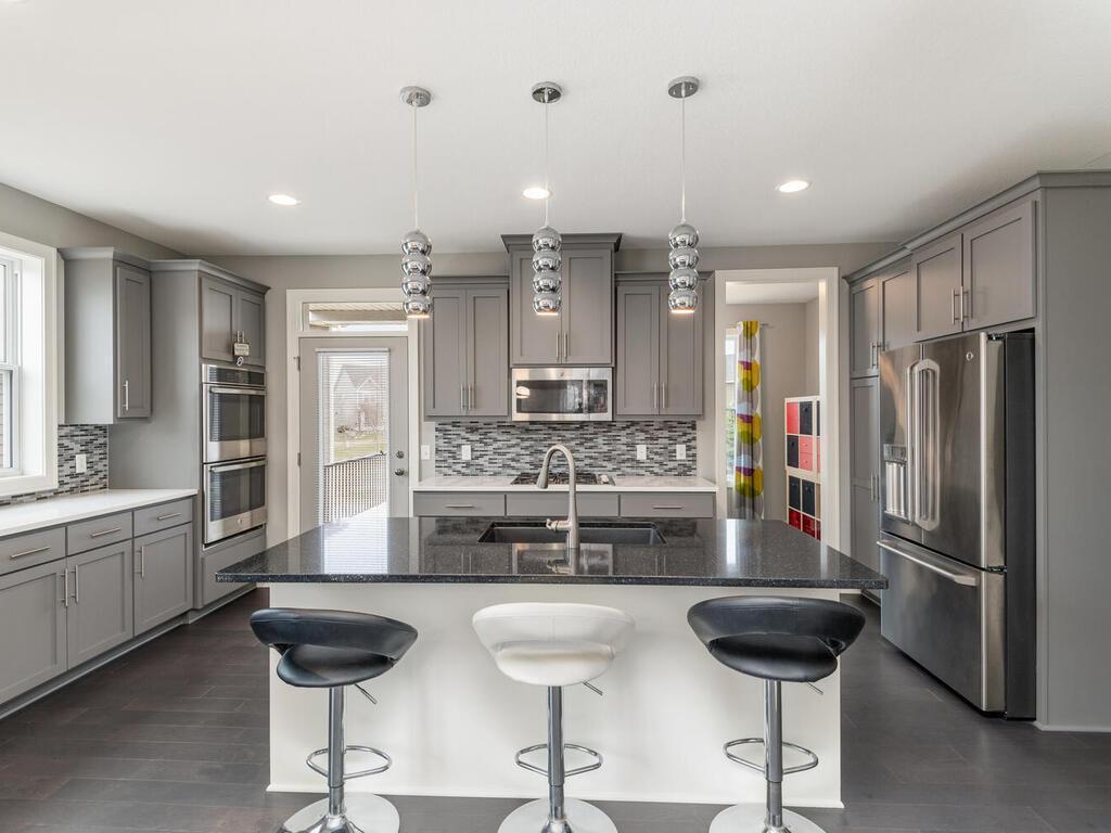 Well-appointed kitchen with large center island, seating, and pendant lighting.
